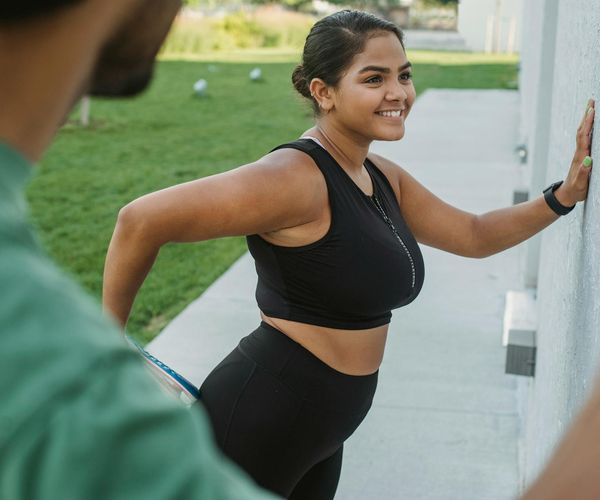 Smiling woman stretching outdoors feeling refreshed and energetic.